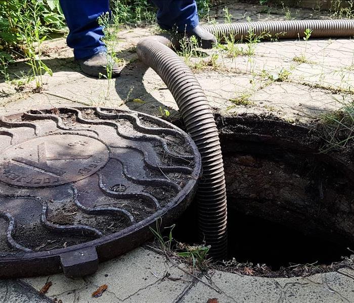 the worker opened the sewer hatch and inserted a hose for cleaning the septic tank. maintenance of communications in a privat